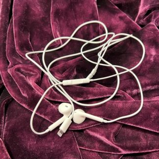 Apple EarPods Lightning øreplugger som er hvite liggende på lilla fløyel