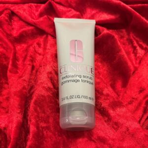Clinique exfoliating scrub gommage tonique liggende på rød fløyel
